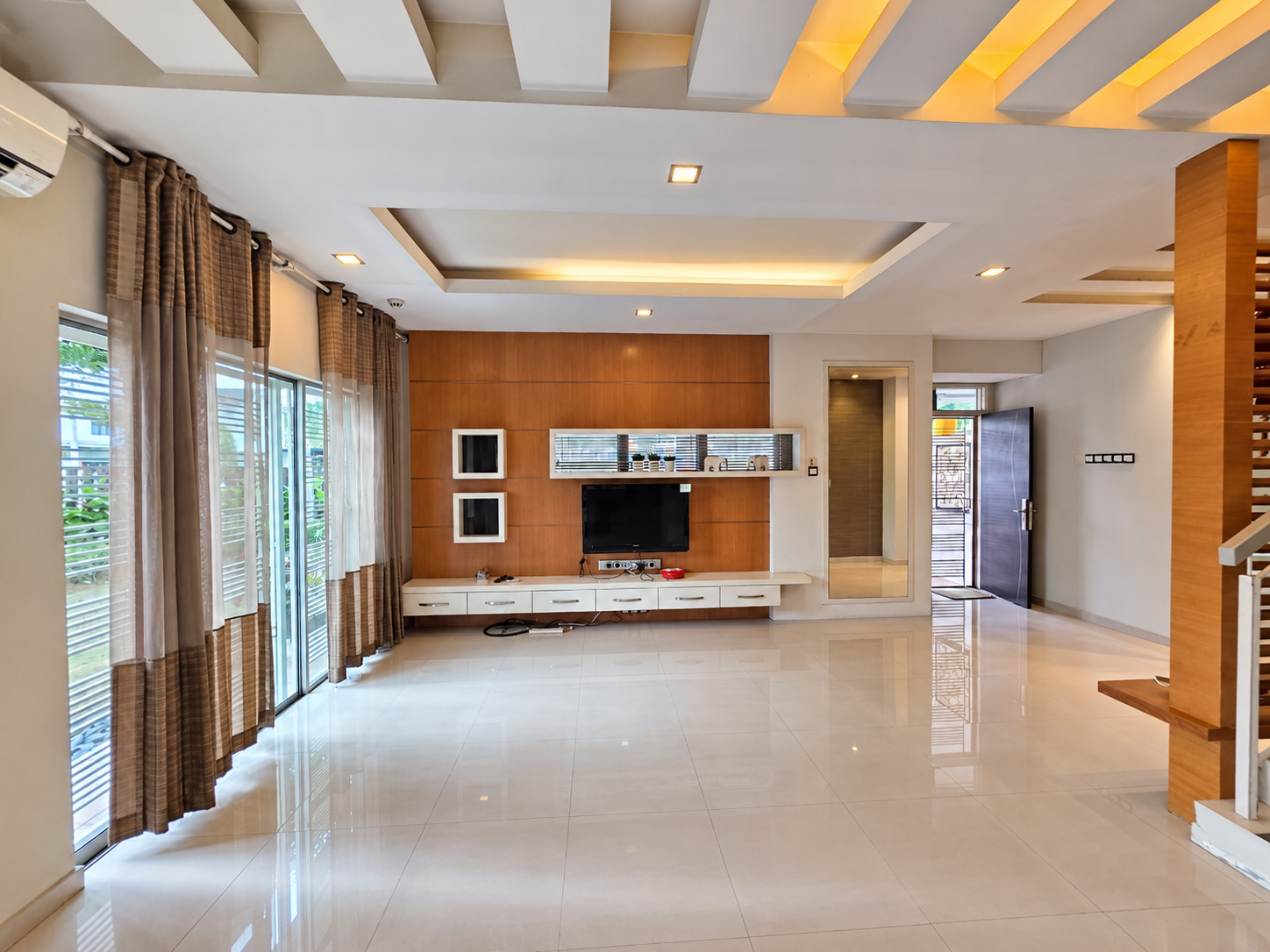 Spacious living area with timber feature wall and recessed ceiling lighting